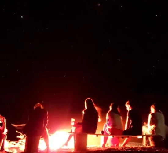 Guests around a bonfire under the stars at our Balabac campsite